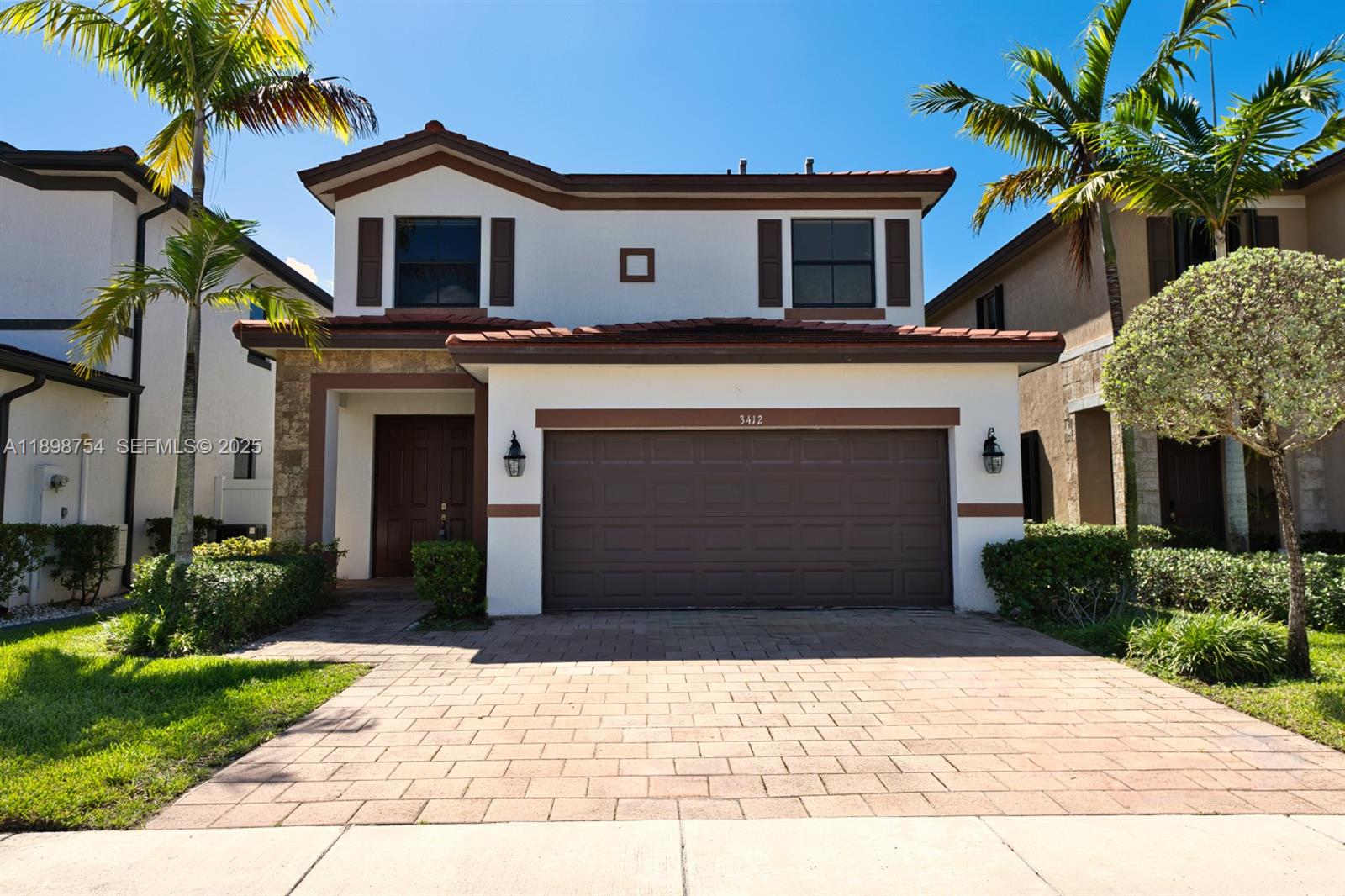 3412 West 103rd Terrace Hialeah, FL 33018 - Photo 1 of 44 a front view of a house with a yard and garage