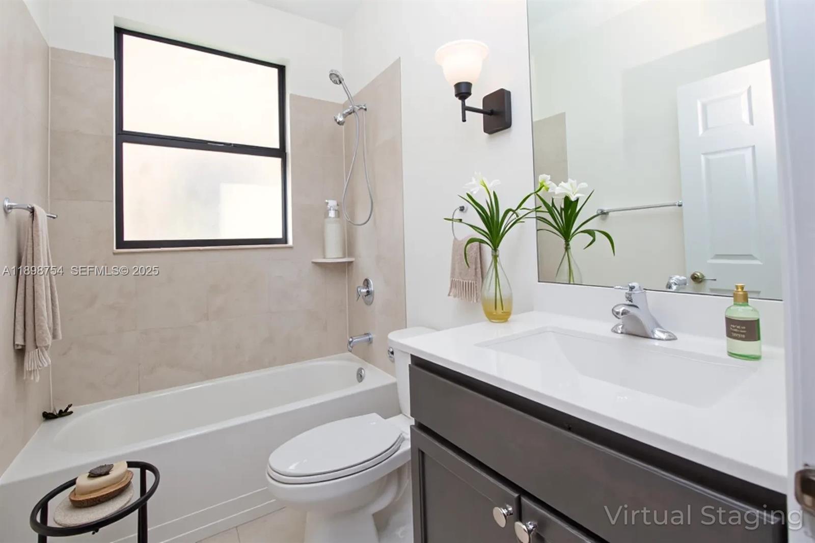 3412 West 103rd Terrace Hialeah, FL 33018 - Photo 16 of 44 a bathroom with a sink a toilet a window and shower