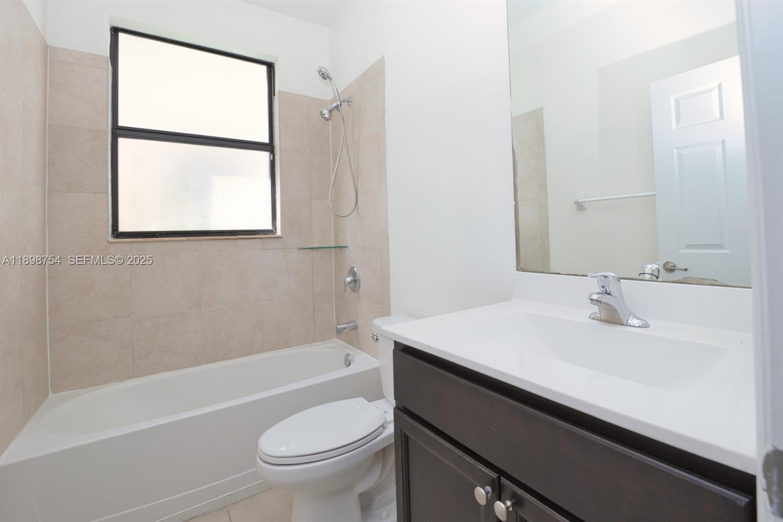 3412 West 103rd Terrace Hialeah, FL 33018 - Photo 17 of 44 a bathroom with a sink a toilet a vanity and bathtub
