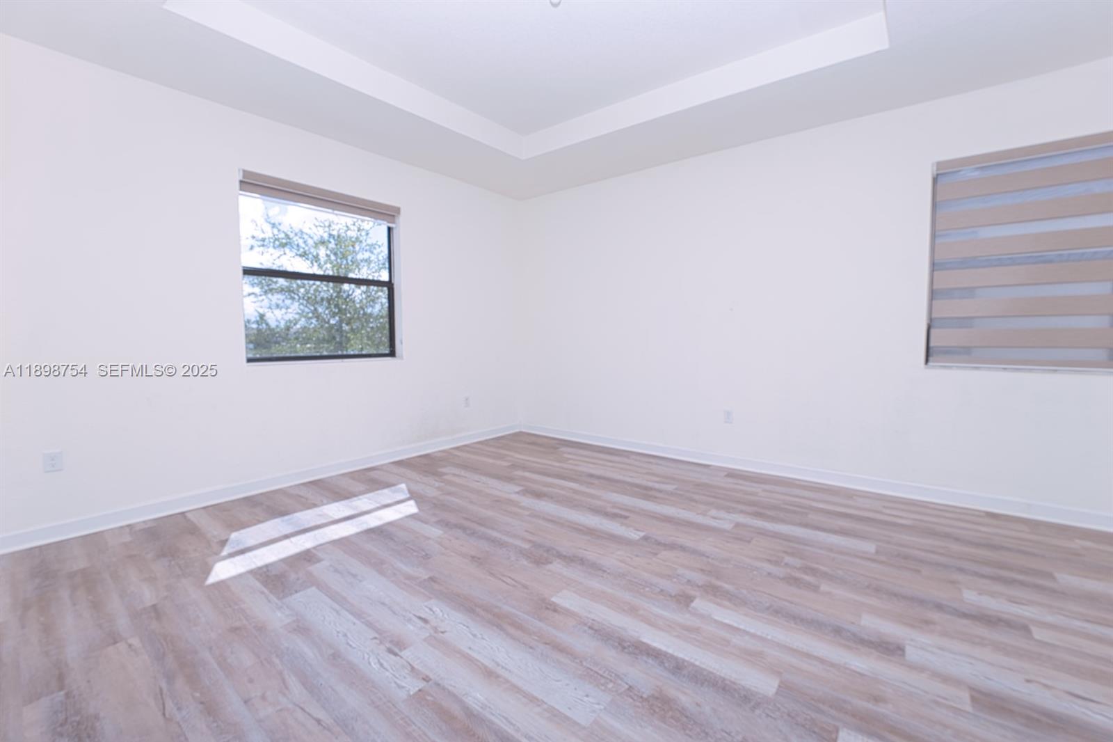 3412 West 103rd Terrace Hialeah, FL 33018 - Photo 20 of 44 a view of empty room with wooden floor and fan