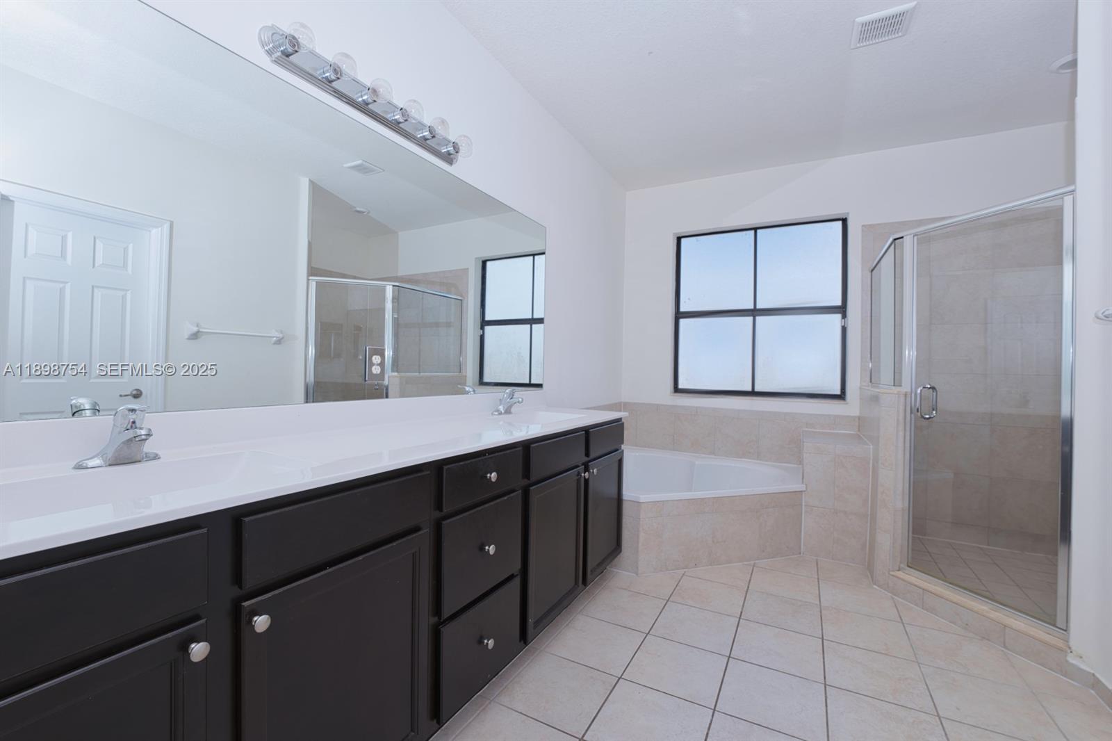 3412 West 103rd Terrace Hialeah, FL 33018 - Photo 24 of 44 a spacious bathroom with a double vanity sink a toilet and a shower