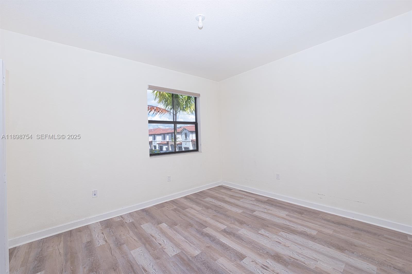 3412 West 103rd Terrace Hialeah, FL 33018 - Photo 37 of 44 a view of empty room with wooden floor