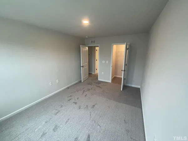an empty room with closet and wooden door