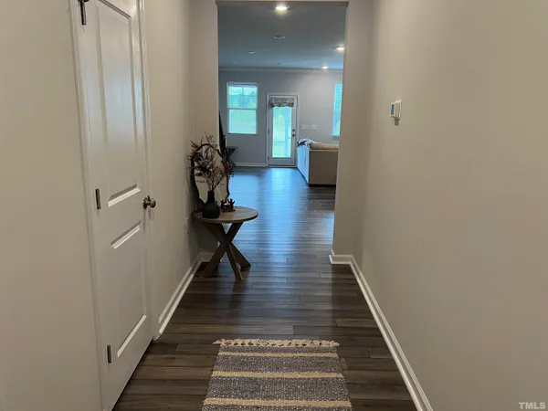 a view of a hallway with wooden floor and stairs