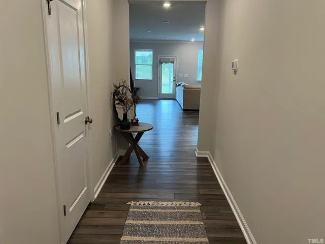 a view of a hallway with wooden floor and stairs