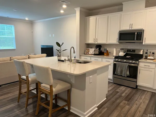a kitchen with a sink a stove a microwave and cabinets