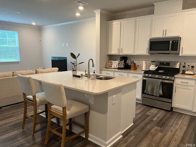 a kitchen with a sink a stove a microwave and cabinets