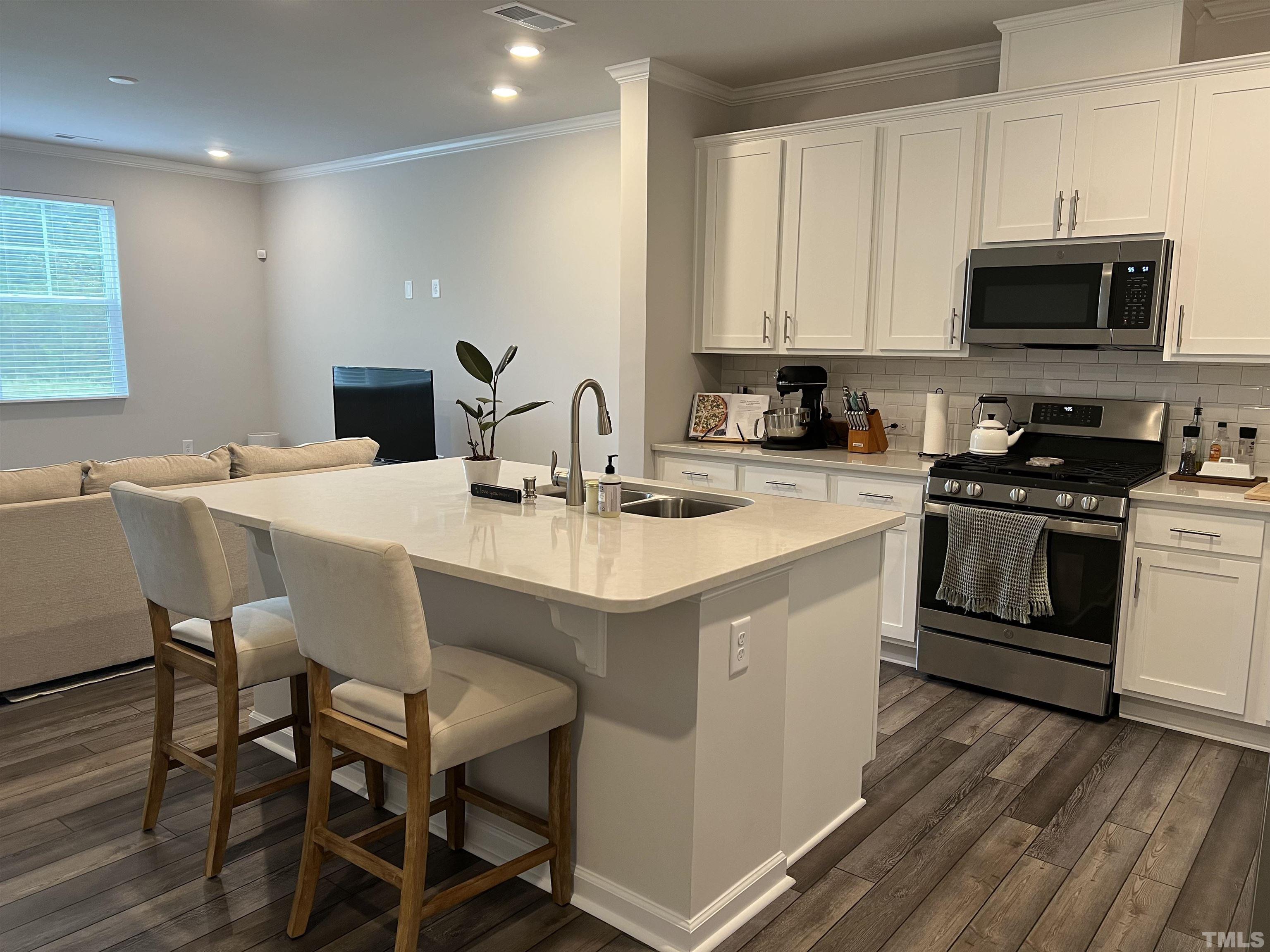4914 Oolite Street, Unit 15 Raleigh, NC 27610 - Photo 3 of 21 a kitchen with a sink a stove a microwave and cabinets