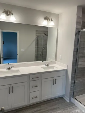 a bathroom with a double vanity sink and mirror