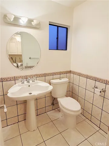 a bathroom with a toilet a sink and mirror