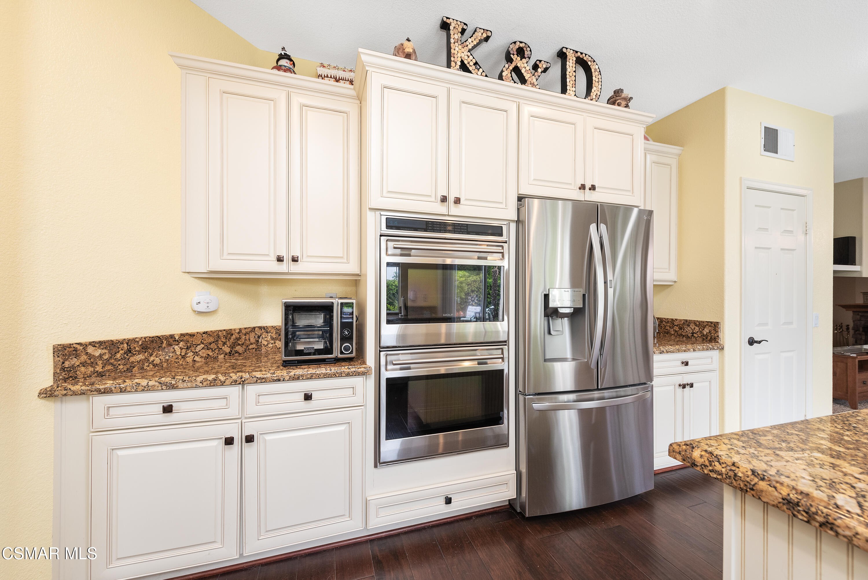 295 Cliffwood Drive Simi Valley, CA 93065 - Photo 16 of 49 a kitchen with stainless steel appliances white cabinets and wooden floors