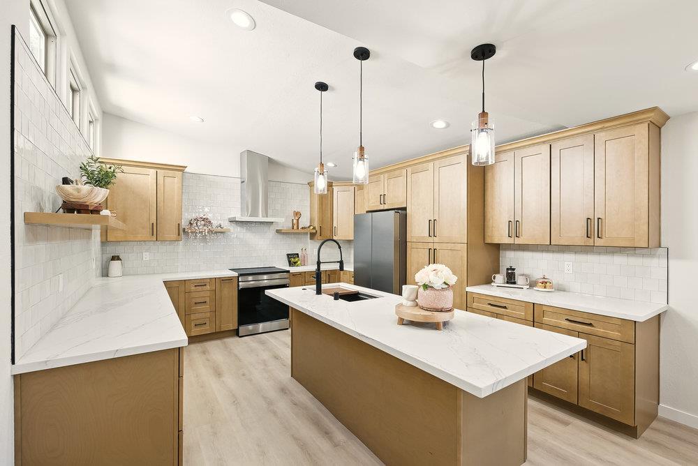 1180 Peterson Drive Gilroy, CA 95020 - Photo 13 of 45 a kitchen with stainless steel appliances kitchen island granite countertop a sink a stove and a wooden floor