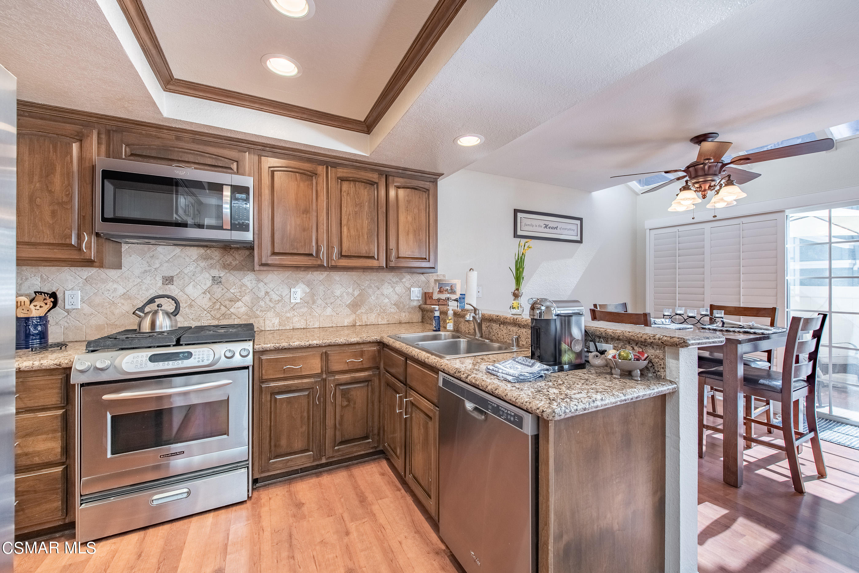 1940 Rory Lane, Unit 3 Simi Valley, CA 93063 - Photo 10 of 33 a kitchen with stainless steel appliances granite countertop a stove top oven a sink dishwasher a dining table and chairs with wooden floor