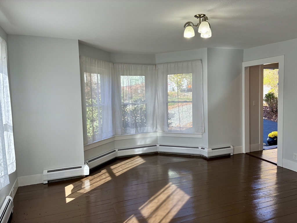 140 Mechanic Street Orange, MA 01364 - Photo 4 of 39 an empty room with wooden floor and windows