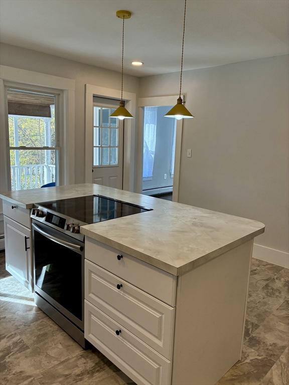 140 Mechanic Street Orange, MA 01364 - Photo 8 of 39 a kitchen with a stove and a chandelier