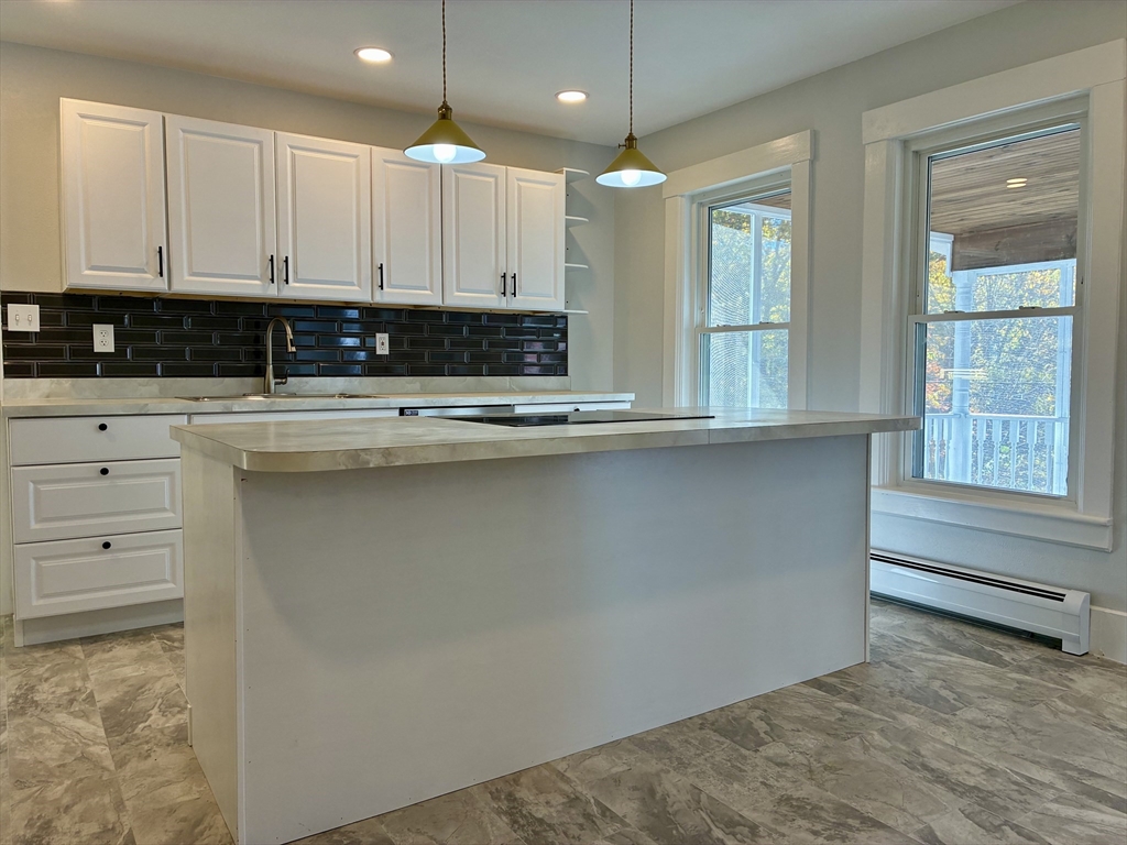 140 Mechanic Street Orange, MA 01364 - Photo 9 of 39 a view of a kitchen with granite countertop cabinets and a wooden floor
