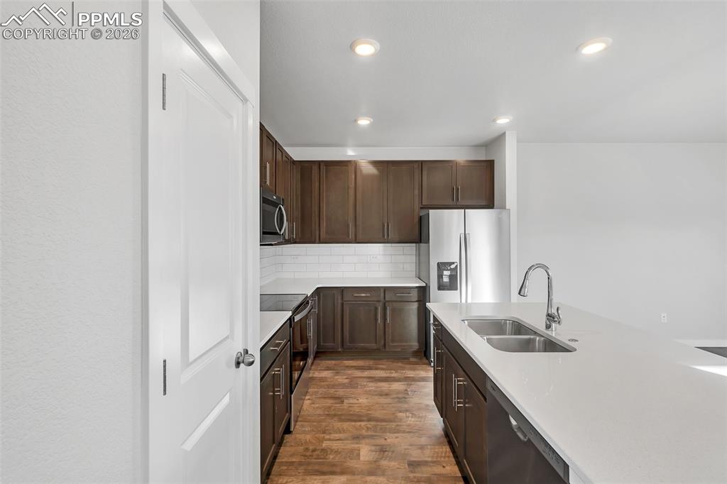 13641 Frost Bitten Grove Colorado Springs, CO 80921 - Photo 8 of 13 a kitchen with kitchen island granite countertop a sink and refrigerator