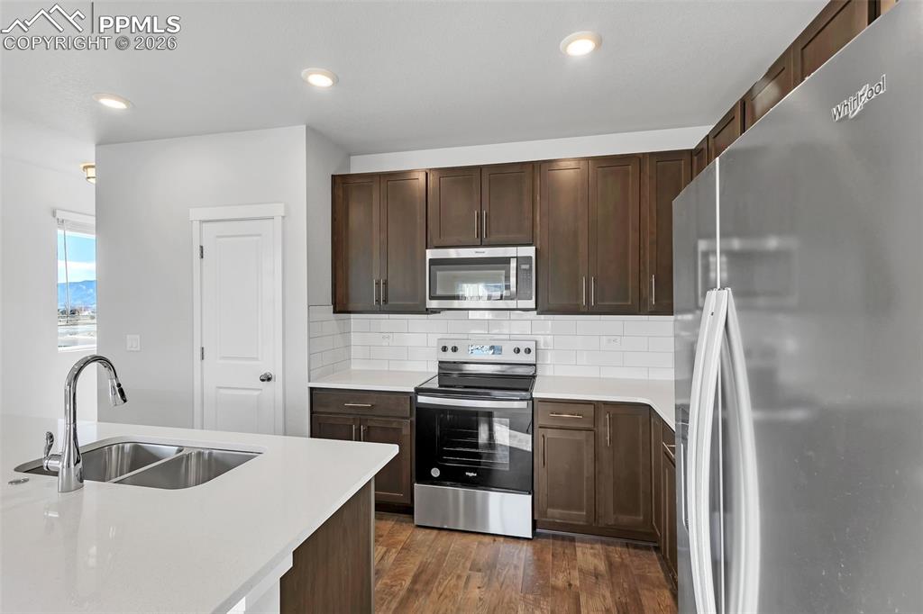 13641 Frost Bitten Grove Colorado Springs, CO 80921 - Photo 9 of 13 a kitchen with stainless steel appliances a stove sink and cabinets