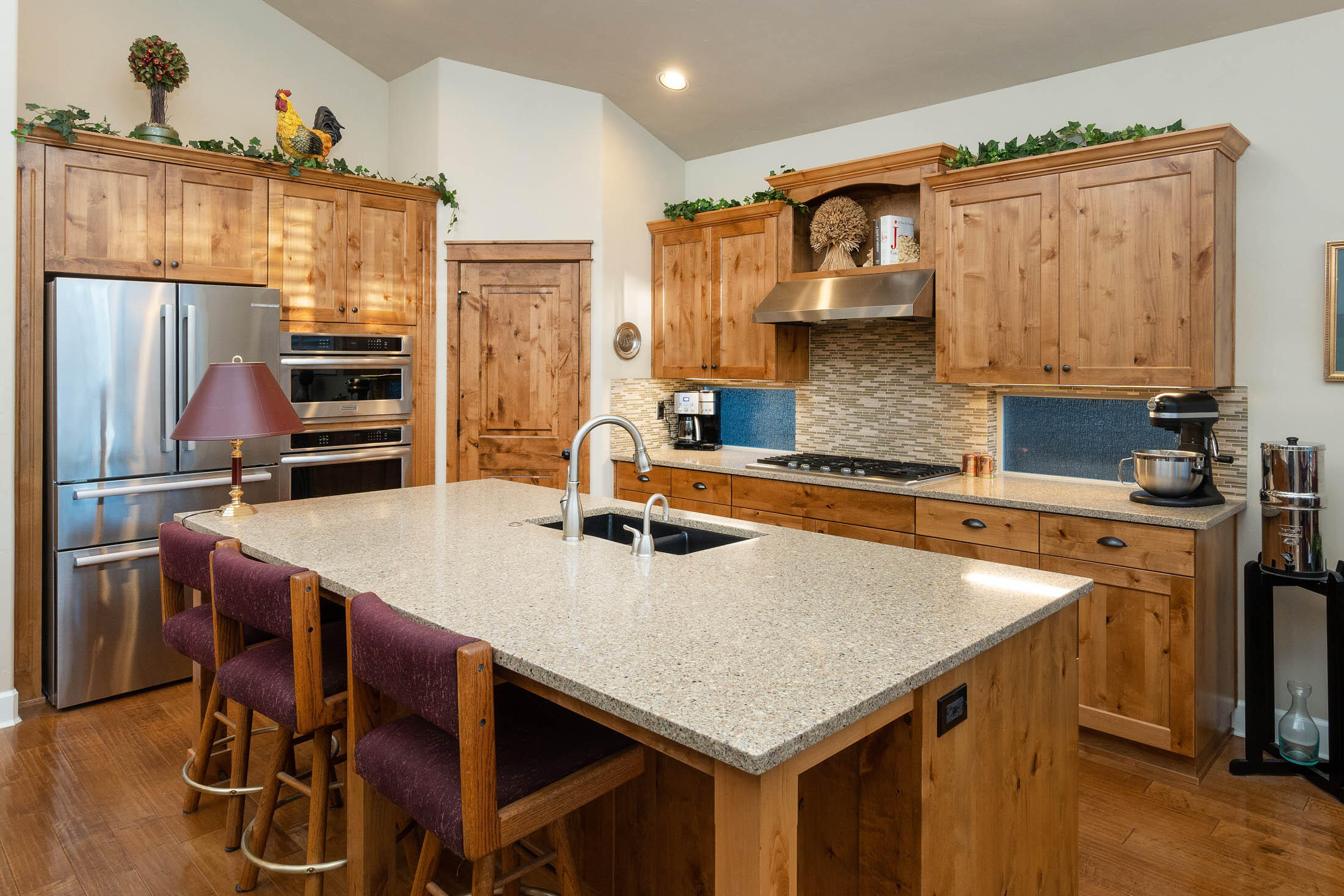 61129 Manhae Loop Bend, OR 97702 - Photo 9 of 44 Kitchen with knotty, solid Alder cabinets and pantry door. Built-in oven and convection microwave. Drop-in stove and large lower cabinet drawers offer extensive storage.