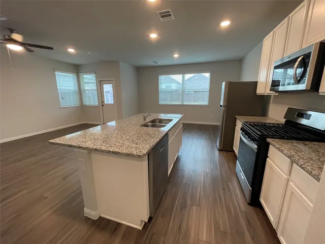 a kitchen with stainless steel appliances granite countertop a stove a sink and a refrigerator