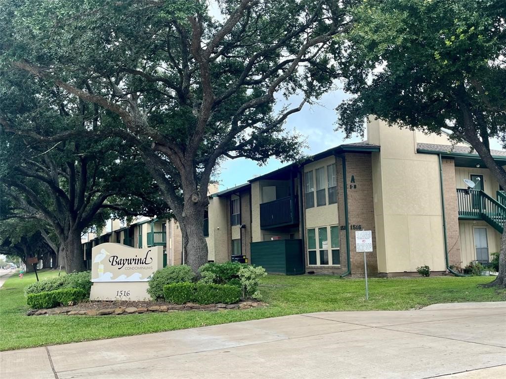 1516 Bay Area Boulevard, Unit 14 Houston, TX 77058 - Photo 2 of 19 a front view of a house with a garden and trees