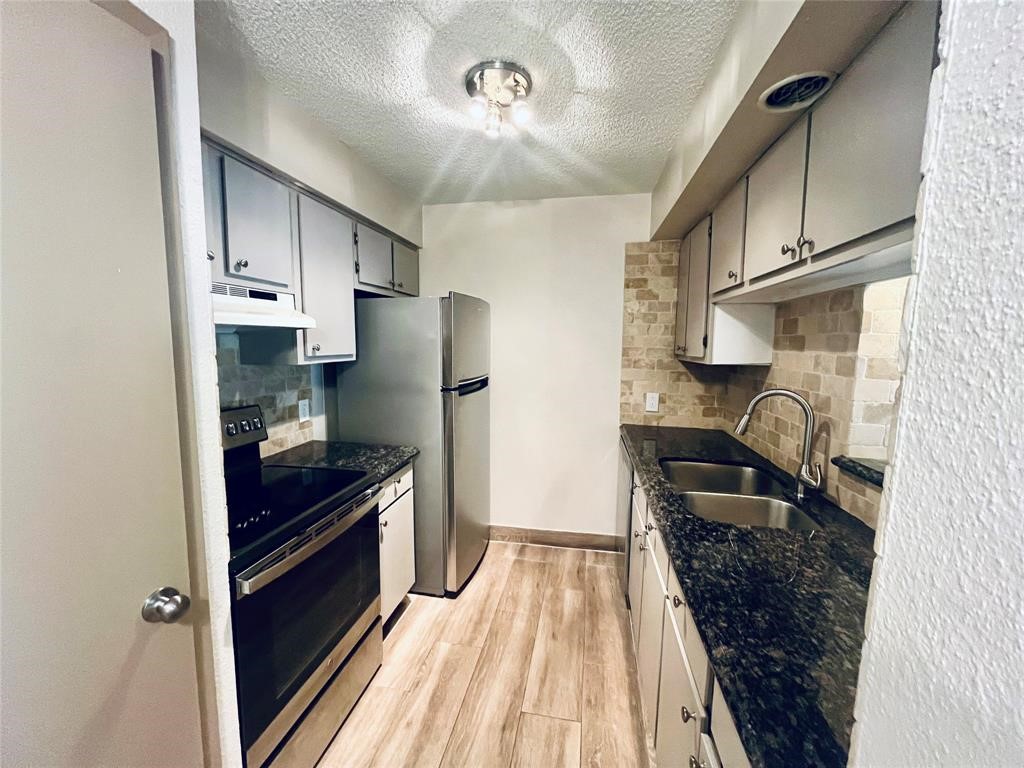 1516 Bay Area Boulevard, Unit 14 Houston, TX 77058 - Photo 10 of 19 a kitchen with granite countertop a refrigerator stove and sink