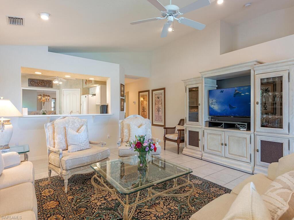 4415 Dover Court, Unit 504 Naples, FL 34105 - Photo 3 of 21 a living room with furniture a flat screen tv and kitchen view