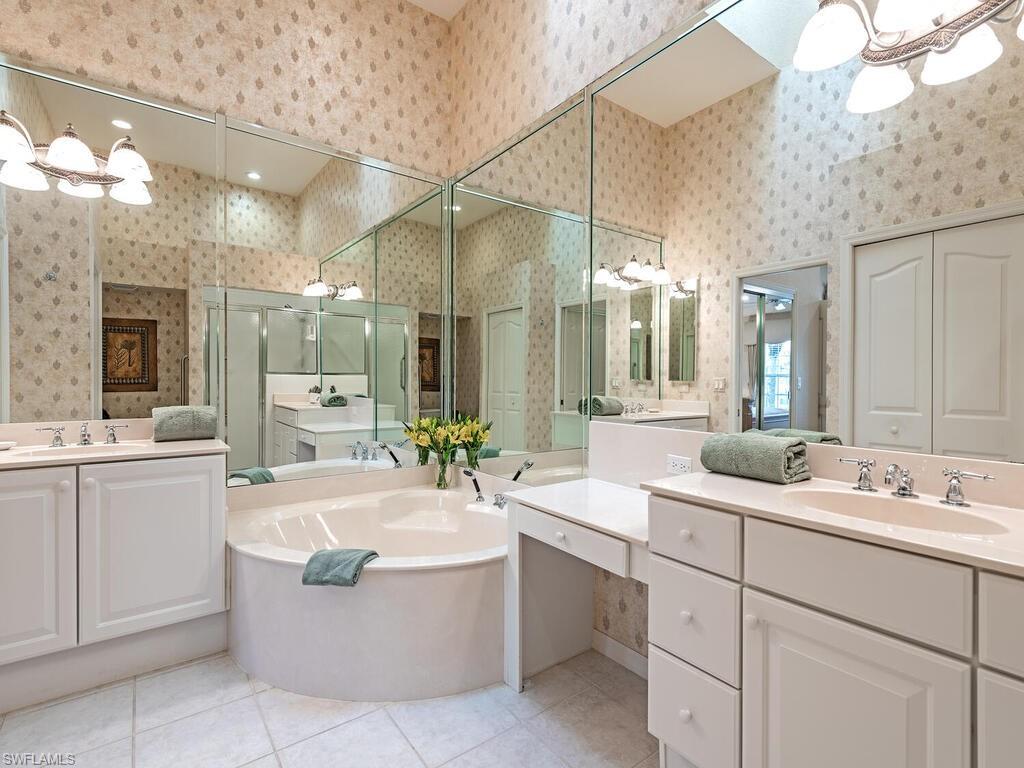 4415 Dover Court, Unit 504 Naples, FL 34105 - Photo 8 of 21 a bathroom with a tub a sink double vanity and a mirror