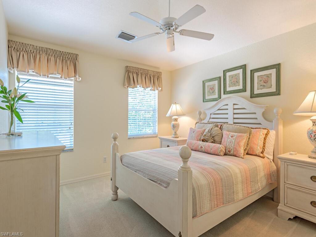 4415 Dover Court, Unit 504 Naples, FL 34105 - Photo 9 of 21 a bedroom with a large bed and a chandelier
