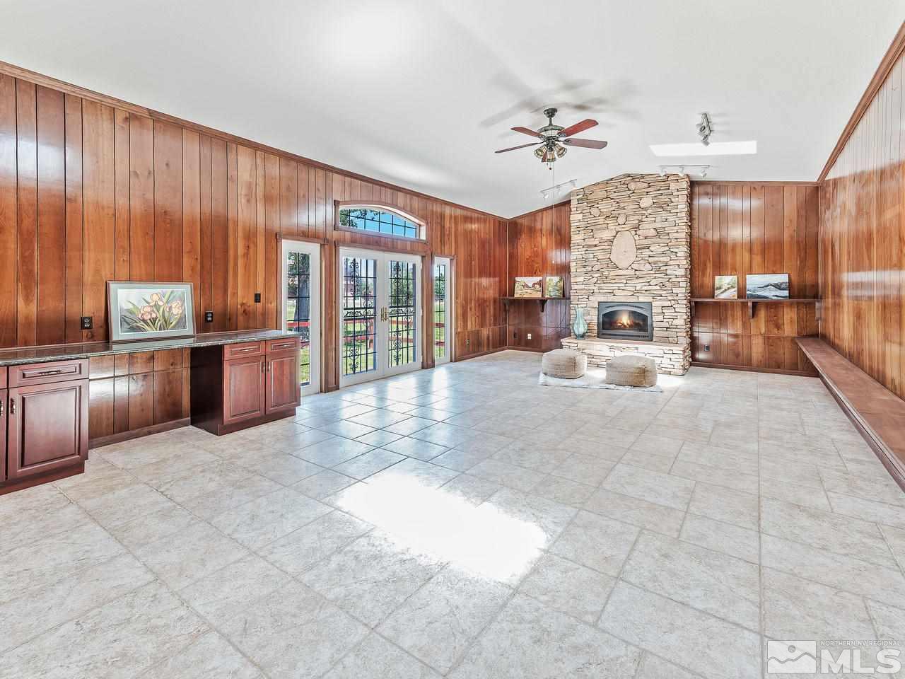2855 Holcomb Ranch Lane Reno, NV 89511 - Photo 21 of 36 a living room with furniture a chandelier a large window and flat screen tv