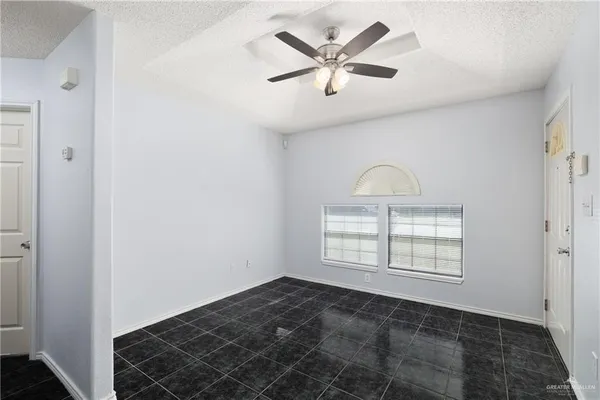 an empty room with windows and fan