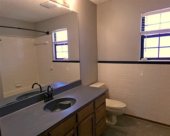 a bathroom with a sink a toilet and a window