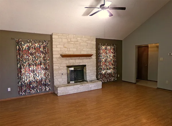 a view of a livingroom with a fireplace and window