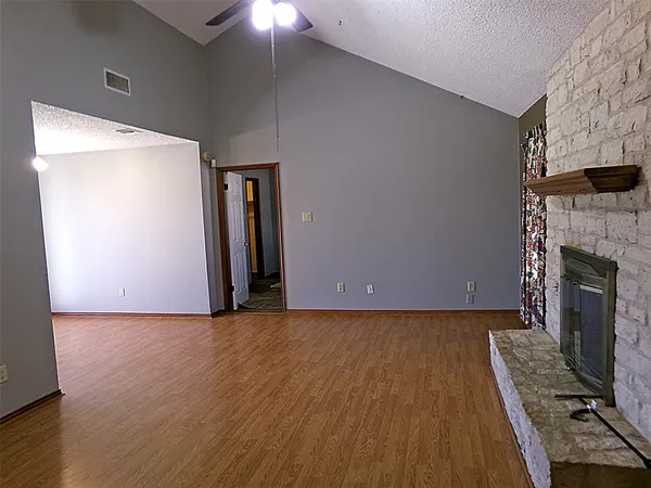 a view of a livingroom with wooden floor and a fireplace