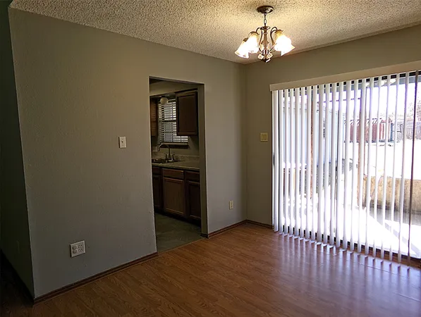 a view of a room with wooden floor electronic appliances and windows