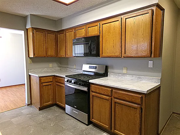 a kitchen with granite countertop cabinets stainless steel appliances and a sink