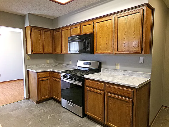 a kitchen with granite countertop cabinets stainless steel appliances and a sink