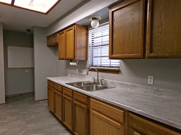 a kitchen with a sink and a wooden cabinets