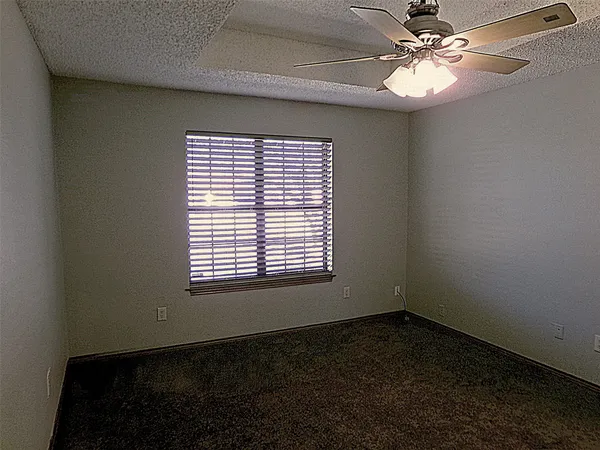 a view of an empty room with a ceiling fan and a window
