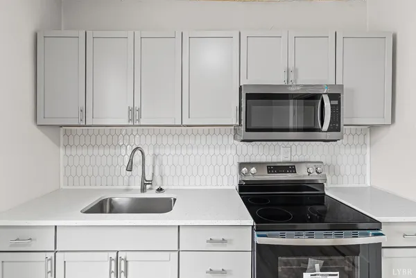 a kitchen with granite countertop white cabinets stainless steel appliances and a sink