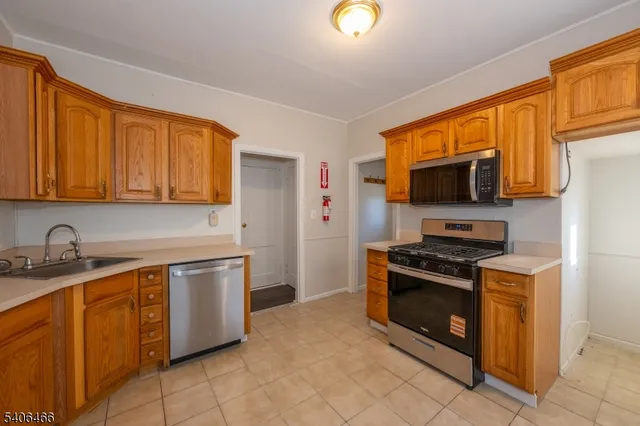 a kitchen with stainless steel appliances granite countertop a stove top oven microwave and refrigerator