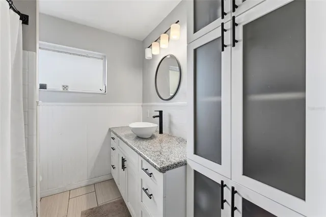 a bathroom with a granite countertop sink and a mirror