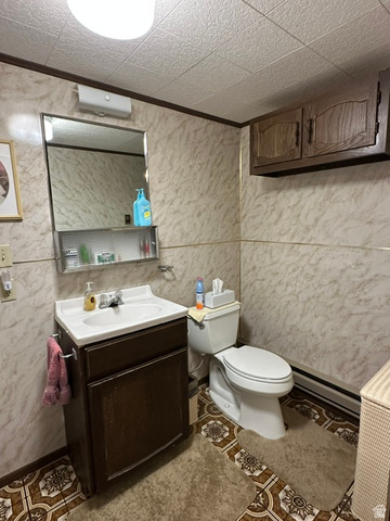 1085 West Elk Road Helper, UT 84526 - Photo 5 of 40 Bathroom featuring a vanity with an integrated sink, a wall-mounted medicine cabinet, and patterned floor tiles