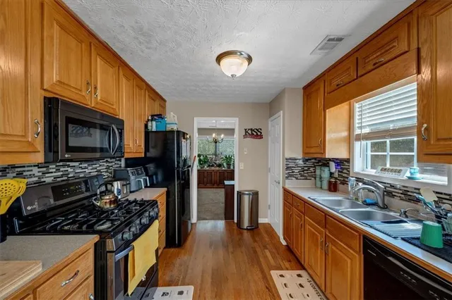 a kitchen with stainless steel appliances a stove sink and microwave