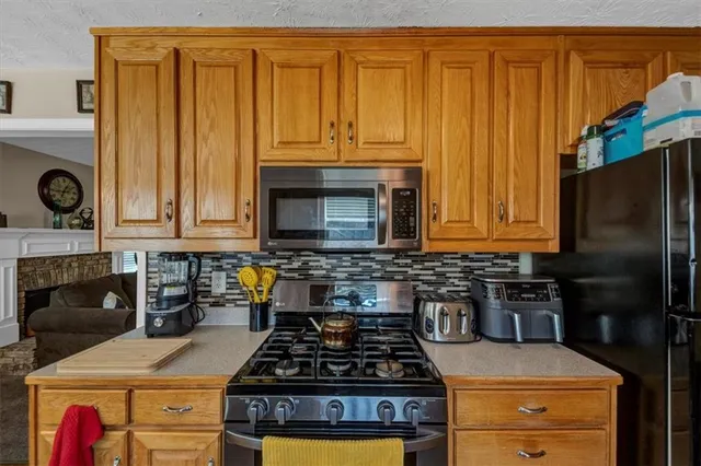 a kitchen with granite countertop stainless steel appliances a stove a sink and dishwasher