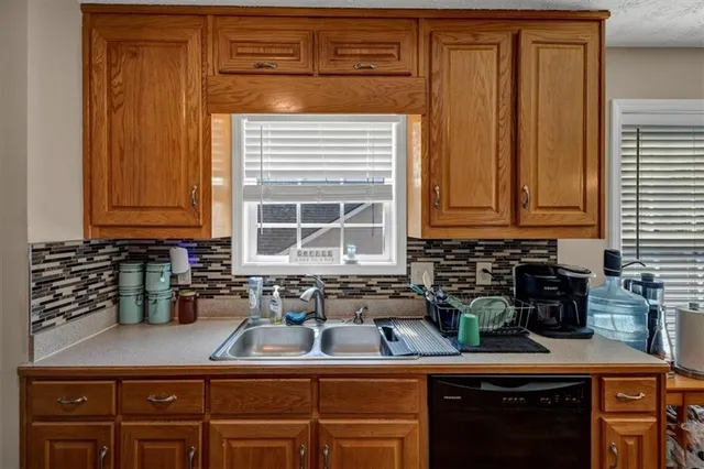 a kitchen with stainless steel appliances granite countertop a sink a stove cabinets and a counter top space