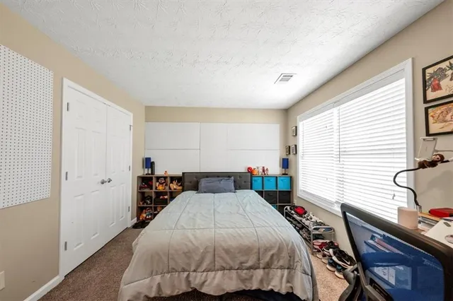 a bedroom with a bed and a dresser with wooden floor
