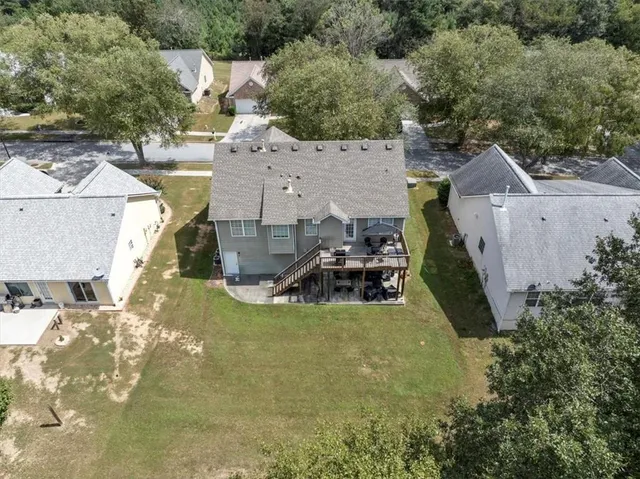 an aerial view of a house with swimming pool and large trees