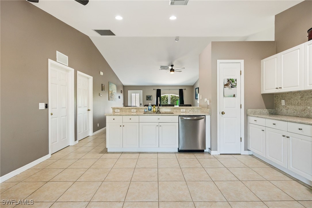 217 Manatee Street Fort Myers, FL 33913 - Photo 17 of 39 a kitchen with white cabinets a sink stove and refrigerator