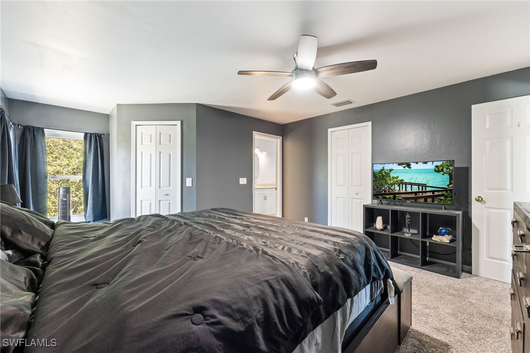 217 Manatee Street Fort Myers, FL 33913 - Photo 19 of 39 a bedroom with a large bed and a chandelier